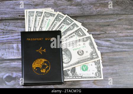 Livre de passeport noir avec un avion et la terre du globe sur sa couverture, concept de voyage et de tourisme, livre de passeport universel, américain USD États-Unis de Banque D'Images