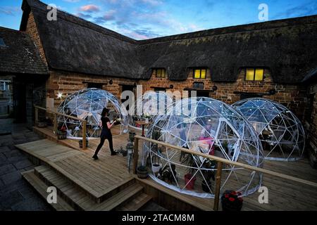 Covid 'iglooss'- dômes géodésiques utilisés au 16th Century Coaching inn The sondes Arms à Rockingham, Corby, Northamptonshire. Les pods de distanciation sociale se sont avérés si populaires auprès des clients du restaurant que le pub a tous les quatre entièrement réservés chaque week-end jusqu'en octobre. Grâce au commerce supplémentaire, les propriétaires familiaux de pubs prévoient d'installer des cabanes de barbecue suédoises dans le jardin à côté. 22 juillet 2020. Photos de JOHN ROBERTSON pour The Telegraph. Banque D'Images