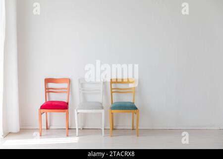 Trois chaises vintage colorées dans l'intérieur de la chambre blanche Banque D'Images