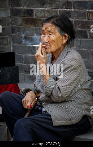 Une chinoise fumante à Pingyao Chine, 14 août 2014 Banque D'Images