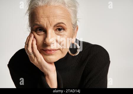 portrait d'affaires, femme d'affaires d'âge moyen en col roulé regardant la caméra sur fond gris Banque D'Images