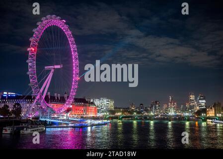 Lumières laser émettant d'un London Eye violet dans un ciel nocturne avec réflexion dans la Tamise, Londres, novembre 2023 Banque D'Images