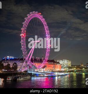 Lumières laser émettant d'un London Eye violet dans un ciel nocturne avec réflexion dans la Tamise, Londres, novembre 2023 Banque D'Images