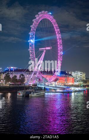 Lumières laser émettant d'un London Eye violet dans un ciel nocturne avec réflexion dans la Tamise, Londres, novembre 2023 Banque D'Images