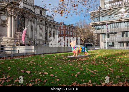 Statue d'un chien corgi portant un manteau coloré dans le parc du Queen Elizabeth II Centre, Westminster, Londres Banque D'Images