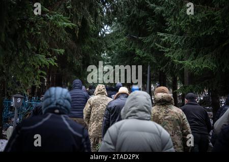 Kiev, Ukraine. 29 novembre 2023. Les personnes en deuil vues aux funérailles du soldat ukrainien Serhiy Pavlichenko, mort au combat dans la région de Zaporizhjia lors de l'invasion continue de l'Ukraine par la Russie, marchent vers son lieu de sépulture dans un cimetière milliaire à Kiev. Depuis que la Russie a commencé son invasion à grande échelle de l'Ukraine le 24 février 2022, des dizaines de milliers de militaires ukrainiens et russes ont été tués. Crédit : SOPA Images Limited/Alamy Live News Banque D'Images