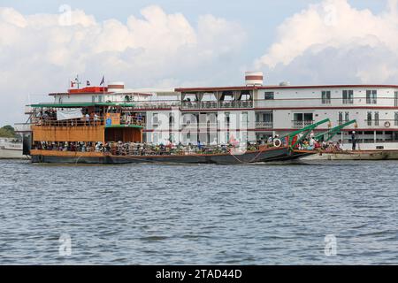 Le ferry cambodgien transportait des passagers Khmers et des véhicules sur le fleuve Tonle SAP près du luxueux navire de croisière du Mékong le Jahan (Heritage Line), Cambodge, Asie Banque D'Images