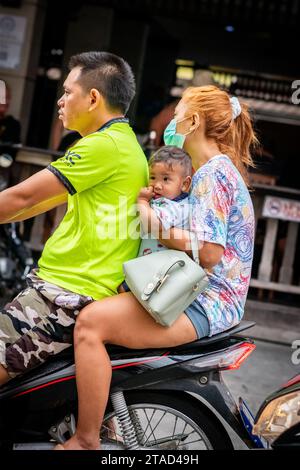 Une famille thaïlandaise voyage sur leur moto à travers les rues animées de la ville de Pattaya, en Thaïlande. Banque D'Images