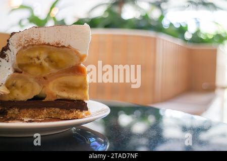 Gâteau Banoffee avec des bananes et de la crème fouettée dans le café restaurant, photo stock Banque D'Images