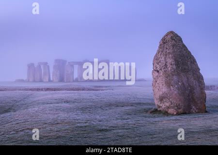 The Heel Stone et Stonehenge à l'aube un matin brumeux et glacial, Wiltshire, Angleterre. Hiver (janvier) 2022. Banque D'Images