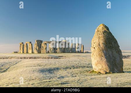 Stonehenge et la pierre de talon à l'aube un matin froid d'hiver glacial, Wiltshire, Angleterre. Hiver (janvier) 2022. Banque D'Images