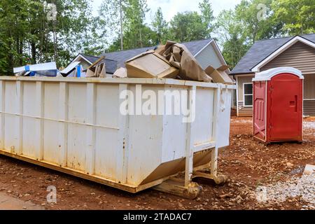 Une benne remplie de débris de déchets de construction est placée près du chantier de construction. Banque D'Images