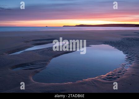 Lever de soleil coloré sur les bassins de marée sur une plage déserte de Harlyn, Cornouailles, Angleterre. Printemps (avril) 2022. Banque D'Images