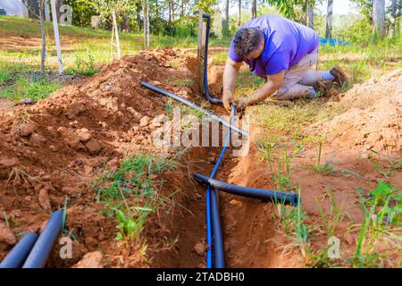 Pour les conduites d'eau souterraines, les plombiers recouvrent les conduites en PVC avec une isolation thermique en mousse PE Banque D'Images