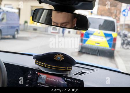 Munich, Allemagne. 22 novembre 2023. Une casquette de policier repose sur le tableau de bord d'une voiture de police. Crédit : Peter Kneffel/dpa/Alamy Live News Banque D'Images