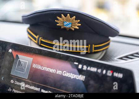 Munich, Allemagne. 22 novembre 2023. Une casquette de policier repose sur le tableau de bord d'une voiture de police. Crédit : Peter Kneffel/dpa/Alamy Live News Banque D'Images