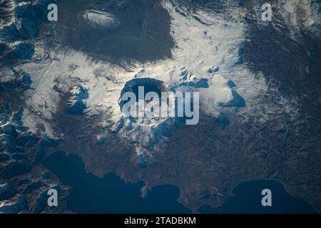 Tatvan, Turquie. 23 novembre 2023. La caldeira de Nemrut, un volcan dormant avec le cratère du lac Nemrut à l'intérieur, comme vu de la Station spatiale internationale 260 miles ci-dessus, le 23 novembre 2023 en orbite terrestre. Alimenté par des sources chaudes, le lac d'eau douce se trouve à une altitude d'environ 7 300 pieds. Crédit : NASA Johnson/NASA/Alamy Live News Banque D'Images