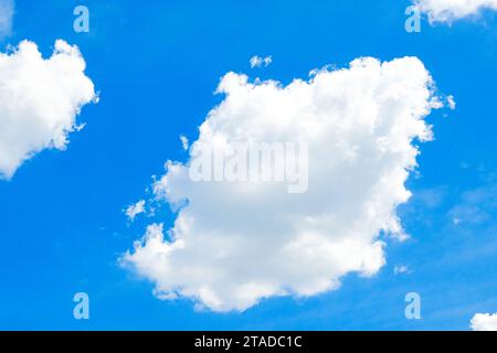 Un magnifique fond de nature présentant un ciel bleu vif rempli de nuages de cumulus blancs et doux par temps clair. Banque D'Images