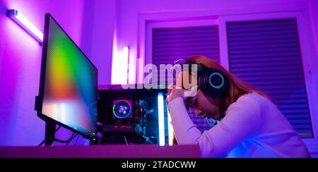 Un joueur asiatique en colère portant un casque de jeu jouant à un jeu vidéo de console de joystick Banque D'Images