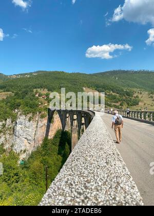 DURMITOR, MONTÉNÉGRO - 15 SEPTEMBRE 2021 : vieil homme marchant au pont Djurdjevica sur la rivière Tara au Monténégro, en Europe. Banque D'Images