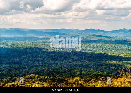 Vue panoramique à grand angle de la vallée luxuriante de la jungle tropicale qui s'étend aux chaînes de montagnes lointaines sous un ciel d'été spectaculaire avec des nuages. Banque D'Images