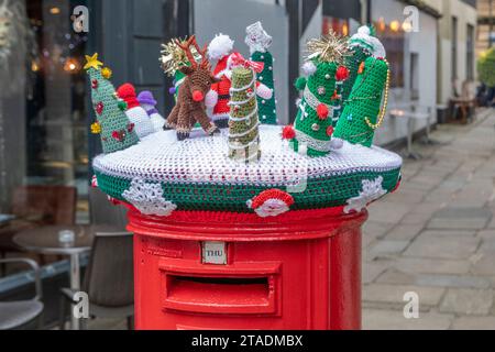 Une couverture décorative festive tricotée sur une boîte aux lettres rouge en Folkestone. Banque D'Images