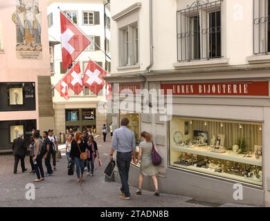 Zurich, Suisse - 03 juin 2017 : personnes dans la rue de Zurich décorées avec des drapeaux de Suisse. Drapeaux suisses sur le bâtiment de façade dans histori Banque D'Images