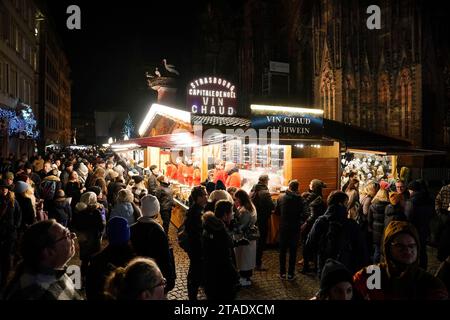 Les amateurs de shopping remplissent les rues de Strasbourg, en France, pendant les marchés de Noël annuels et dégustent du vin chaud ou du vin épicé chaud. Les marchés sont l'un des plus anciens d'Europe, opérant depuis plus de 400 ans. Les estimations sont plus de deux millions de personnes visiteront la ville duirng la saison 2023 Yule. Banque D'Images