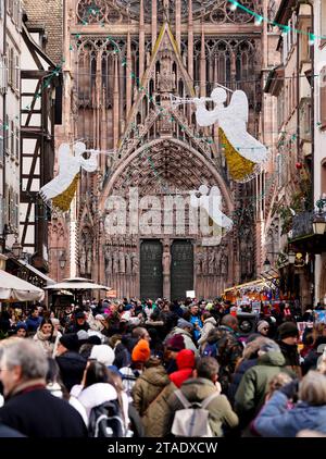 Les acheteurs remplissent les rues de Strasbourg, en France, devant la cathédrale de notre-Dame pendant les marchés de Noël annuels dans la ville de l'est de la France. Les marchés sont l'un des plus anciens d'Europe, opérant depuis plus de 400 ans. Les estimations sont plus de deux millions de personnes visiteront la ville duirng la saison 2023 Yule. Banque D'Images