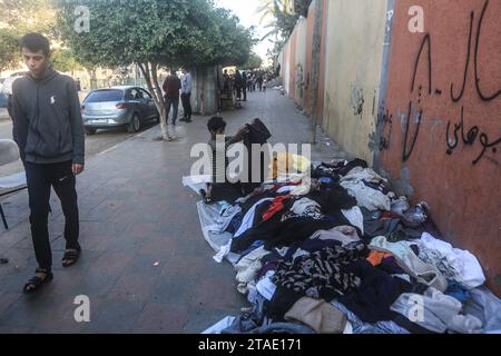 Khan Yunis, Territoires palestiniens. 30 novembre 2023. Un enfant vend des vêtements le long d’un trottoir, le septième jour de la trêve entre Israël et le Hamas. Crédit : Mohammed Talatene/dpa/Alamy Live News Banque D'Images