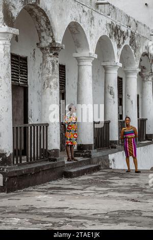 Guides touristiques en robes colorées au château d'Elmina, Ghana Banque D'Images