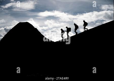 France, haute-Savoie (74), massif du Chablais, montagnes du Giffre, Sixt-fer-à-Cheval, réserve naturelle de Sixt-fer-à-Cheval, randonneurs marchant entre le Col de Sageroux et la Tête de Pérua (2296m), avec la Pointe Rousse des chambres (2660m) en arrière-plan Banque D'Images