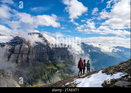 France, haute-Savoie (74), massif du Chablais, montagnes du Giffre, Sixt-fer-à-Cheval, réserve naturelle de Sixt-fer-à-Cheval, randonneurs marchant entre le Col de Sageroux et la Tête de Pérua (2296m), le Cirque-du-fer-à-Cheval dans le fond brumeux Banque D'Images