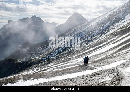 France, haute-Savoie (74), massif du Chablais, montagnes du Giffre, Sixt-fer-à-Cheval, réserve naturelle de Sixt-fer-à-Cheval, randonneurs marchant entre le Col de Sageroux, et la Tête de Pérua (2296m), dans le fond brumeux vous pouvez voir la Pointe de Bellegarde (2514m) et la Pointe Rousse des chambres (2660m) sur la droite Banque D'Images