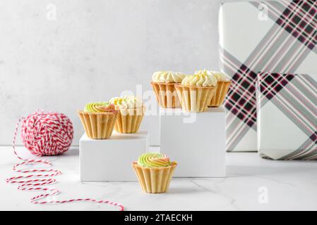 mini gâteaux à la crème de noël sur un fond clair dans des tartelettes sablées. Photo de haute qualité Banque D'Images