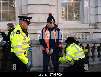 Whitehall, Londres, Royaume-Uni. 28 novembre 2023. Les manifestants de Just Stop Oil étaient de retour à Londres aujourd'hui. Ils ont commencé leur manifestation à Trafalgar Square. Lorsque deux manifestants âgés ont marché sur la route à l'extérieur de Downing Street, ils ont été rapidement arrêtés et menottés par la police du met. La manifestante Julie Redman, 72 ans, qui a été arrêtée aujourd'hui est une grand-mère de sept enfants de Fife. Elle a dit : « Je suis désespérée par la crise climatique. Il accélère à un rythme alarmant et pourtant, notre gouvernement continue de délivrer de nouveaux permis pour le pétrole et le gaz. Ce sont mes petits-enfants qui vont supporter le plus gros du climat Banque D'Images