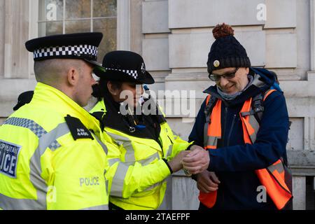 Whitehall, Londres, Royaume-Uni. 28 novembre 2023. Les manifestants de Just Stop Oil étaient de retour à Londres aujourd'hui. Ils ont commencé leur manifestation à Trafalgar Square. Lorsque deux manifestants âgés ont marché sur la route à l'extérieur de Downing Street, ils ont été rapidement arrêtés et menottés par la police du met. La manifestante Julie Redman, 72 ans, qui a été arrêtée aujourd'hui est une grand-mère de sept enfants de Fife. Elle a dit : « Je suis désespérée par la crise climatique. Il accélère à un rythme alarmant et pourtant, notre gouvernement continue de délivrer de nouveaux permis pour le pétrole et le gaz. Ce sont mes petits-enfants qui vont supporter le plus gros du climat Banque D'Images