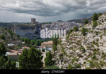 Vues sur le village médiéval d'Alcala del Jucar à flanc de montagne avec la tempête approchant à l'horizon. Castilla la Mancha. Albacete. Banque D'Images