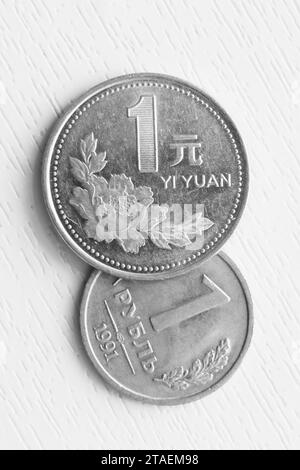 Photo verticale d'un rouble russe et d'un yuan chinois sur fond blanc. Banque D'Images