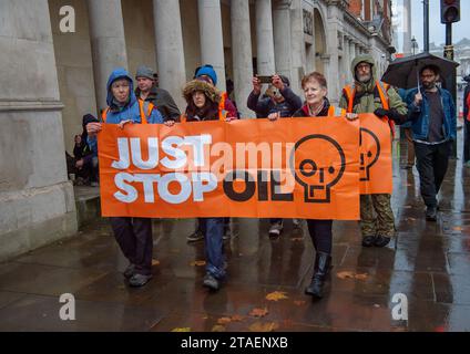 Londres, Royaume-Uni. 27 novembre 2023. Les manifestants de Just Stop Oil étaient de retour à Londres aujourd'hui. Ils ont commencé leur manifestation à Trafalgar Square, puis se sont arrêtés devant Downing Street. Alors qu'ils tentaient de s'asseoir sur la route en face de la Chambre des communes, ils ont été rapidement arrêtés et menottés par la police du met. Les cinq manifestants ont été emmenés dans des fourgonnettes de la police. La peine maximale encourue pour obstruction délibérée d ' une autoroute en Angleterre et au pays de Galles est de 51 semaines de prison. Les contrevenants peuvent également être condamnés à une amende. Just Stop Oil a été décrit comme un « groupe de résistance civile non violent exigeant du gouvernement britannique qu'il arrête li Banque D'Images