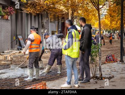 Constructeurs hommes réparant la route. Travailleurs de la construction travaillant sur une nouvelle route avec du ciment. Travailleurs sur une construction routière, industrie et travail d'équipe. Novembre-3 Banque D'Images