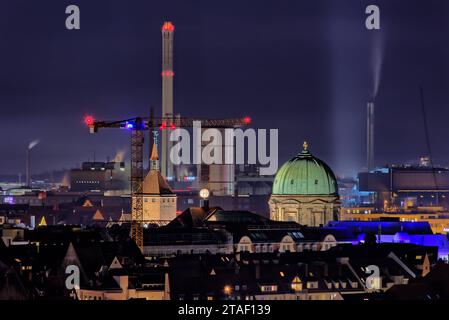 Blick über die Dächer von Nürnberg BEI Nacht mit den beleuchteten Türmen der Kirche von St. Elisabeth und des Weißen Turmes. Im hintergrund des Heizkraftwerk mit rauchenden Schornsteinen. *** Vue sur les toits de Nuremberg la nuit avec les tours illuminées de St. Eglise Elisabeths et la Tour Blanche en arrière-plan la centrale combinée de chaleur et d'électricité avec cheminées à fumée 20220302-HDR Kuppel Kraftwerk crédit : Imago/Alamy Live News Banque D'Images