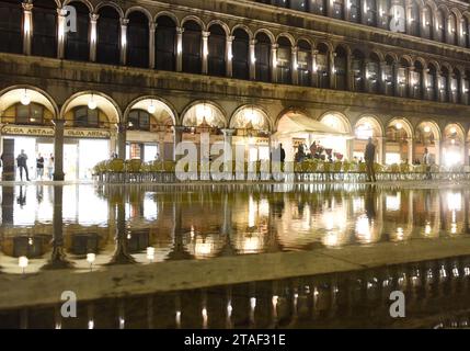 Venise, Italie - 07 juin 2017 : café sur la place San Marco avec réflexion sur l'eau la nuit à Venise. Banque D'Images