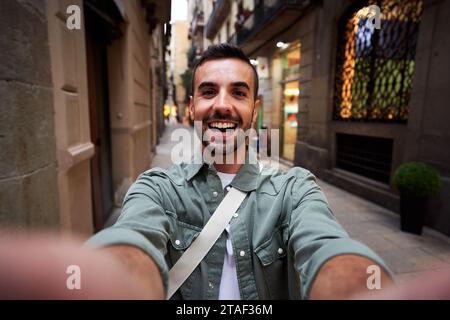 Heureux selfie d'un jeune homme caucasien dans une vieille ville de Barcelone. Banque D'Images