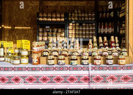 Bucarest, Roumanie, 30 novembre 2023 : des pots et des bouteilles de confiture bio traditionnels sont exposés à la vente au marché de Noël West Side à Drumul Taberei neig Banque D'Images