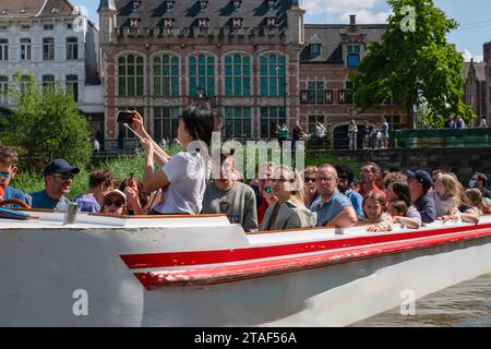 Gand, Belgique - juillet 25 2023 : vue rapprochée des touristes qui font un tour en bateau et prennent des photos sur le canal Banque D'Images