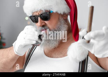 Mauvais Père Noël avec le whisky de boisson de cigare à la fête de Noël, closeup Banque D'Images