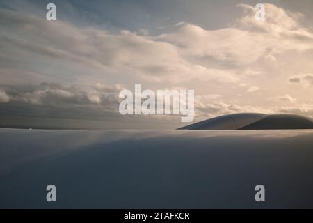 Beau ciel bleu profond clair sur une épaisse couche de nuages à l'atmosphère stratosphérique vue de la fenêtre de l'avion située au-dessus de l'aile de l'avion. Banque D'Images