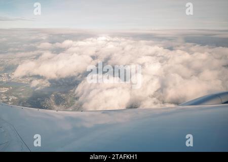 Beau ciel bleu profond clair sur une épaisse couche de nuages à l'atmosphère stratosphérique vue de la fenêtre de l'avion située au-dessus de l'aile de l'avion. Banque D'Images