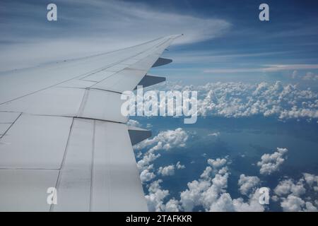 Beau ciel bleu profond clair sur une épaisse couche de nuages à l'atmosphère stratosphérique vue de la fenêtre de l'avion située au-dessus de l'aile de l'avion. Banque D'Images